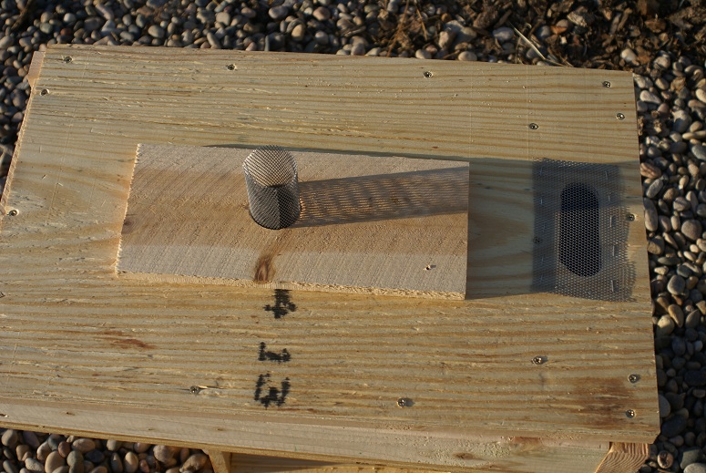 The underside of the top of the feeder